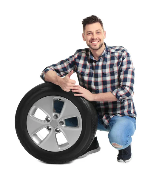 Jeune homme avec pneu de voiture sur fond blanc — Photo