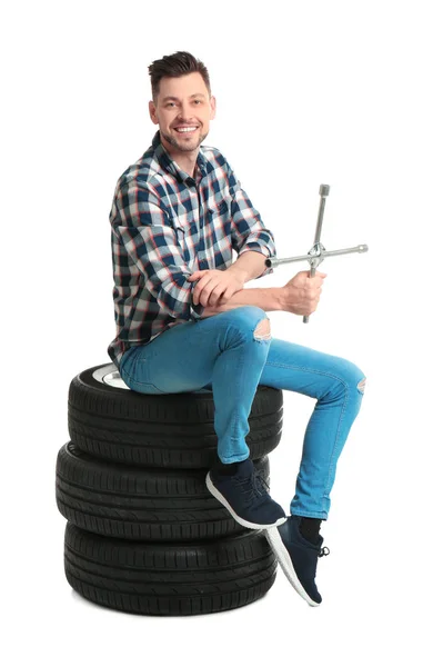 Hombre joven con neumáticos de coche sobre fondo blanco —  Fotos de Stock