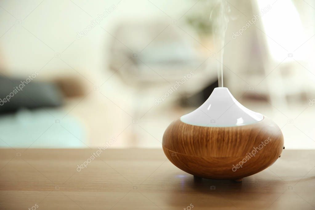 Aroma oil diffuser on table indoors