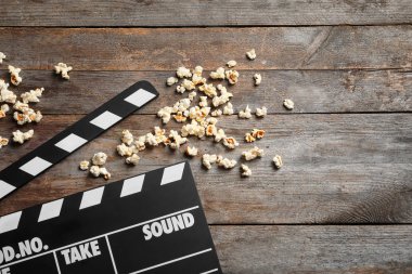 Klaket ve ahşap arka plan üzerinde patlamış mısır