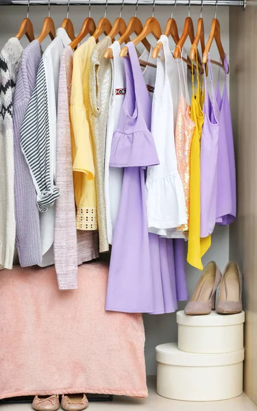 Различные одежды на вешалках в шкафу — стоковое фото