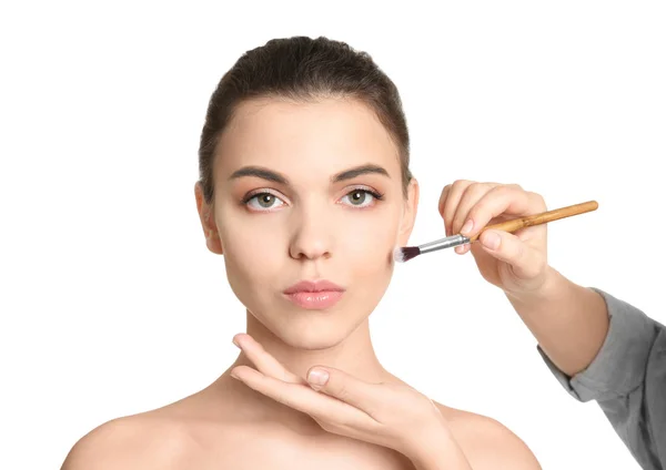 Visage konstnären tillämpa makeup på kvinnans ansikte mot vit bakgrund. Professionella kosmetiska produkter — Stockfoto