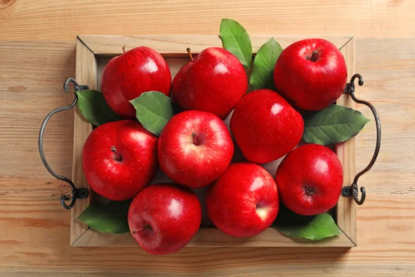 Поднос с спелыми красными яблоками на деревянном фоне — стоковое фото