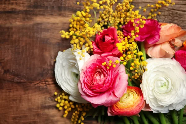 Прекрасні квіти рунункули та мімози на дерев'яному фоні — стокове фото