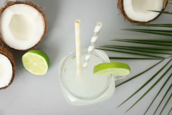 Mason jar met kokoswater en verse noten op een grijze achtergrond, bovenaanzicht — Stockfoto