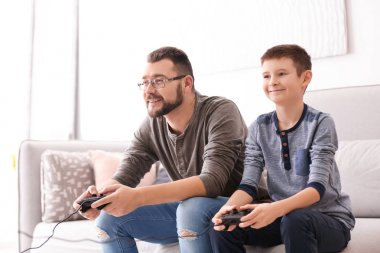 Küçük bir çocuk ve babası birlikte evde video oyunu oynamak