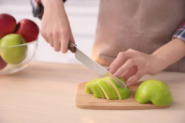 Mujer cortando manzana madura en la mesa — Foto de Stock