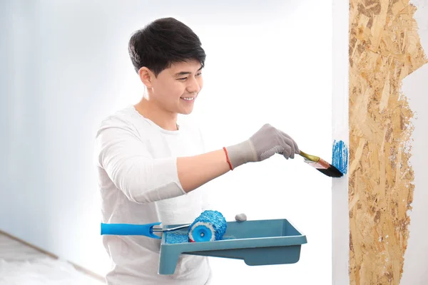Manliga dekoratör målning vägg med borste inomhus — Stockfoto