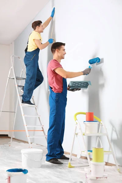 Мужчины-декораторы ремонтируют пустую комнату — стоковое фото