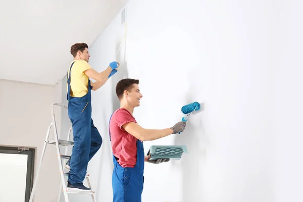 Мужчины-декораторы ремонтируют пустую комнату — стоковое фото