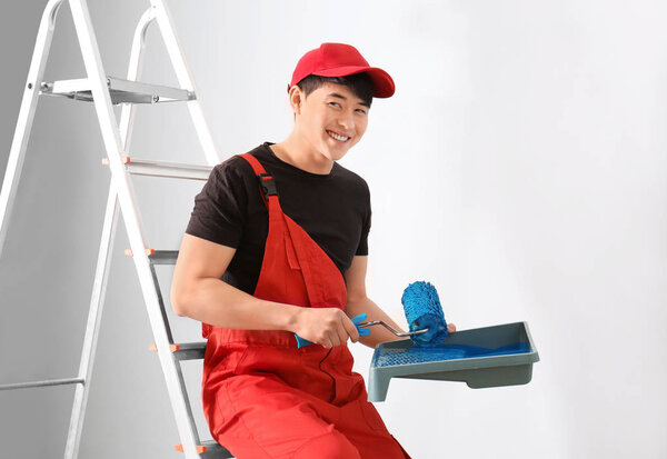 Male decorator with paint and roller indoors