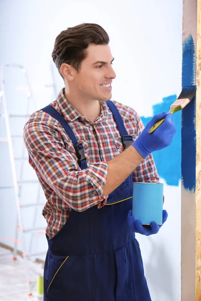 Чоловічий декоратор малює стіну з пензлем в приміщенні — стокове фото