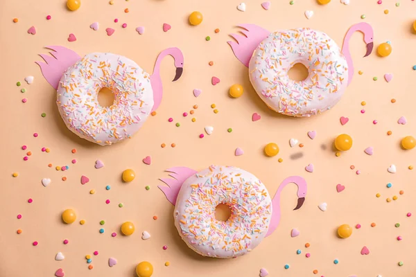 Frescos y sabrosos donuts, caramelos y salpicaduras sobre el fondo de color — Foto de Stock
