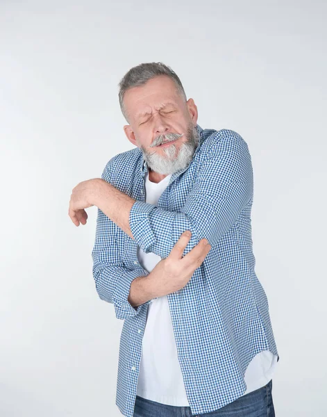 Homem que sofre de dor no cotovelo no fundo claro — Fotografia de Stock