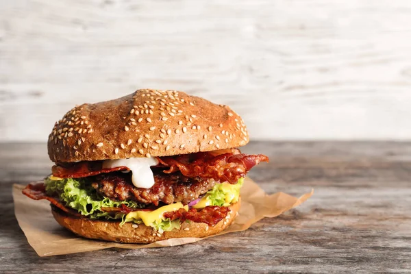 Chutné burger se slaninou na dřevěný stůl — Stock fotografie