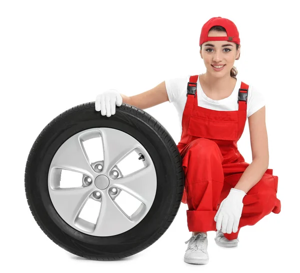 Feminino mecânico em uniforme com pneu de carro no fundo branco — Fotografia de Stock