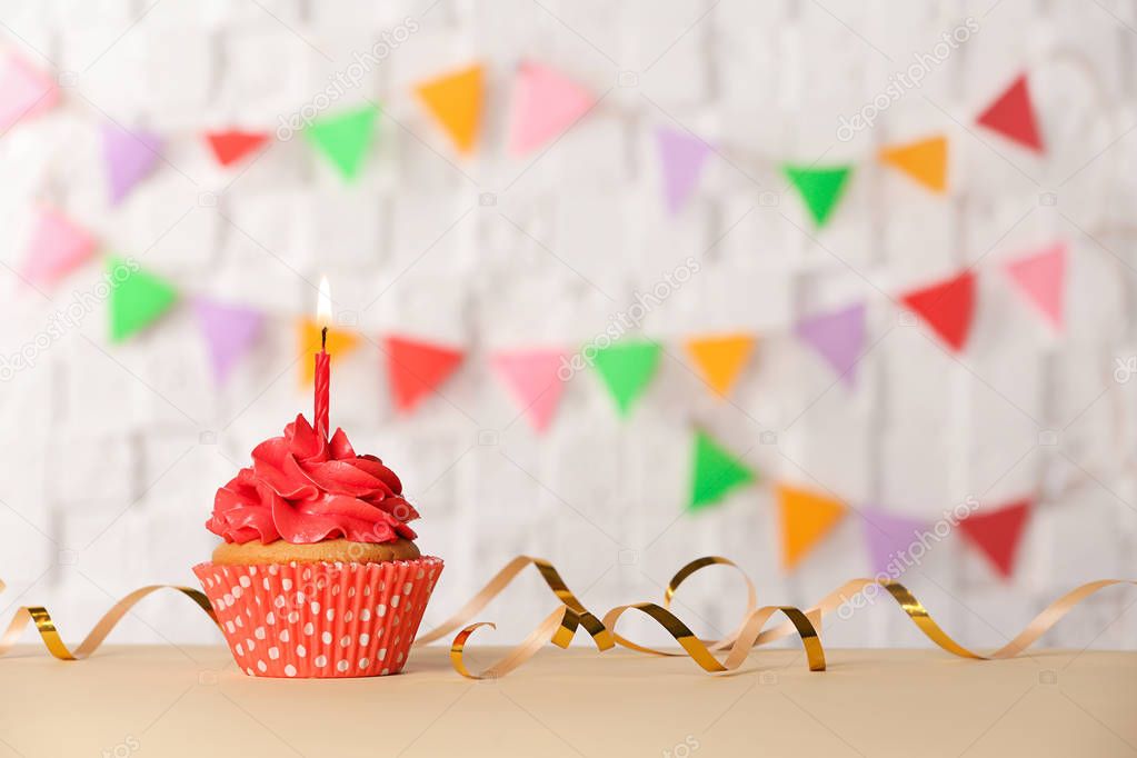 Birthday cupcake with candle against blurred background