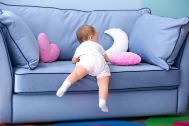 Şirin Bebek oturma odasında kanepede tırmanma