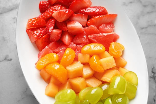 Bord met vers gesneden fruit op tafel, close-up — Stockfoto