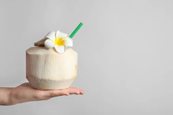 Mujer con bebida fresca de coco en nuez sobre fondo claro, primer plano —  Fotos de Stock