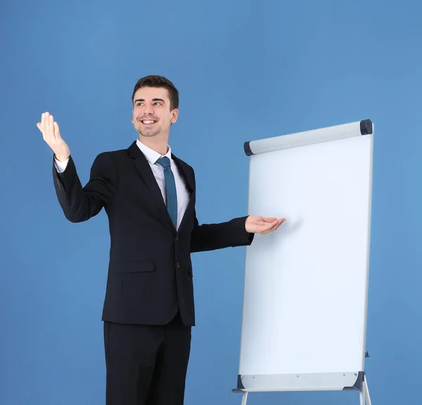 Бізнес-тренер показує презентацію на дошці фліп-чартів на кольоровому фоні — стокове фото