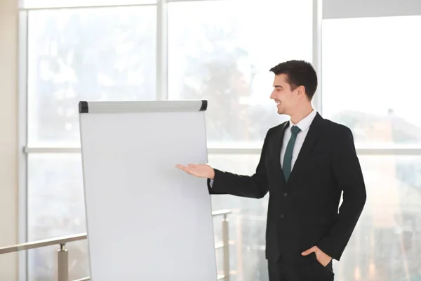 Entrenador de negocios dando presentación en el tablero del rotafolio en interiores —  Fotos de Stock