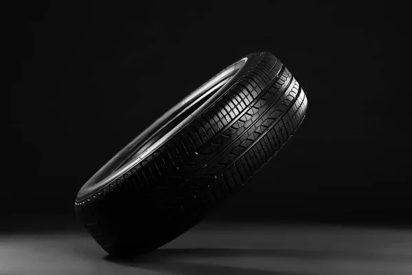 Neumático de coche nuevo sobre fondo negro — Foto de Stock