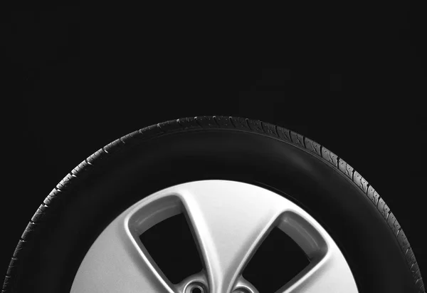 Neumático de coche con llanta sobre fondo negro, primer plano —  Fotos de Stock
