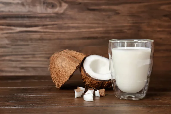 Vidrio con leche de coco y nueces frescas sobre fondo de madera — Foto de Stock