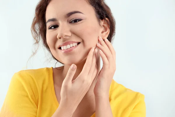 Mooie jonge vrouw met acneprobleem op lichte achtergrond — Stockfoto