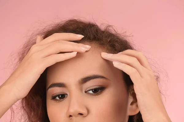 Mooie jonge vrouw met acneprobleem op kleur achtergrond — Stockfoto