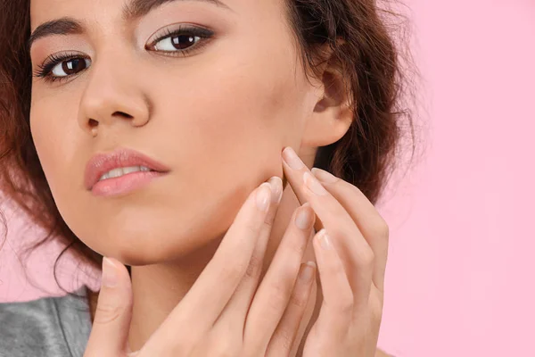 Mooie jonge vrouw met acneprobleem op kleur achtergrond — Stockfoto