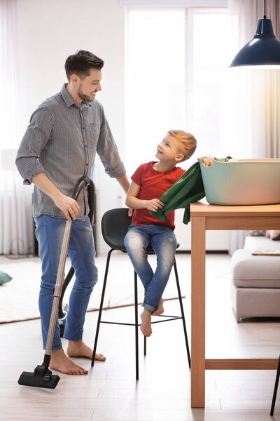 Little boy and his dad cleaning their house together