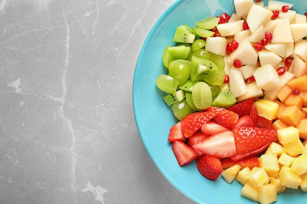 Plate with fresh cut fruits on table, top view — Stock Photo, Image