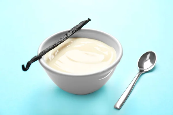 Bowl with vanilla pudding and sticks on color background — Stock Photo, Image