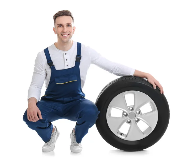 Mužské mechanik s auto pneumatiky na bílém pozadí — Stock fotografie