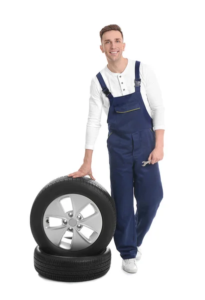 Mecánico masculino con neumáticos de coche sobre fondo blanco —  Fotos de Stock