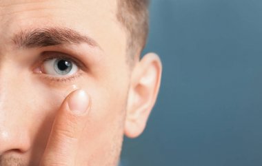 Koyarak Kontakt lens renk arka plan üzerinde onun gözünde genç adam