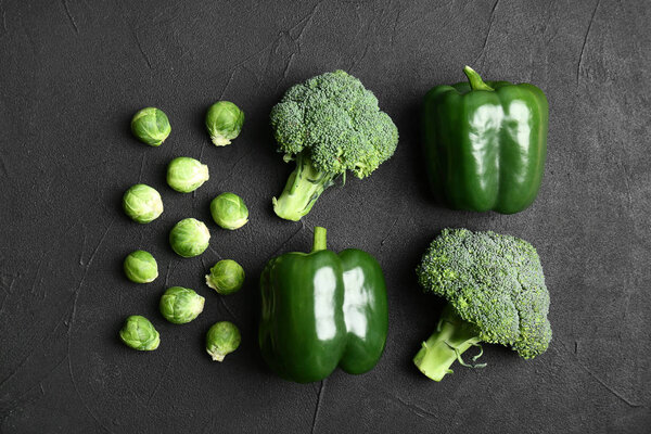 Различные зеленые овощи на темном фоне, вид сверху
