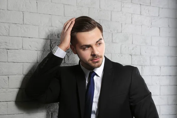 Retrato de jovem com cabelo bonito no fundo da parede de tijolo — Fotografia de Stock