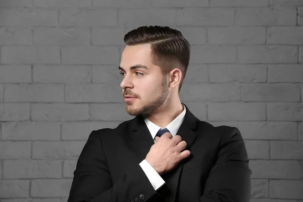 Portrait of young man with beautiful hair on brick wall background — Stock Photo, Image