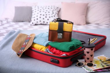 Yatakta farklı kişisel sayfalar ile açık bavul