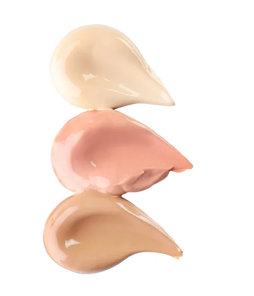 Different shades of liquid foundation on white background. Professional makeup products