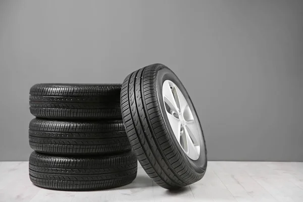 Neumáticos de coche cerca de pared gris —  Fotos de Stock