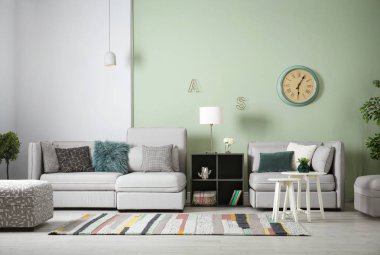 Modern oturma odasının içi rahat kanepeyle dolu.