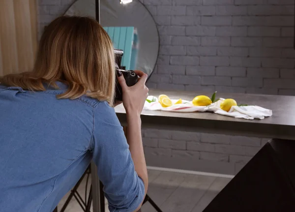 Mulher tirando foto de comida com câmera profissional em estúdio — Fotografia de Stock