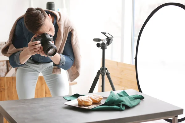 Young man taking picture of food in photo studio — Stock Photo, Image