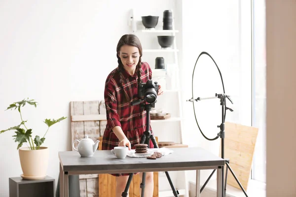 Ung kvinna med professionell kamera förbereder mat sammansättning i fotostudio — Stockfoto