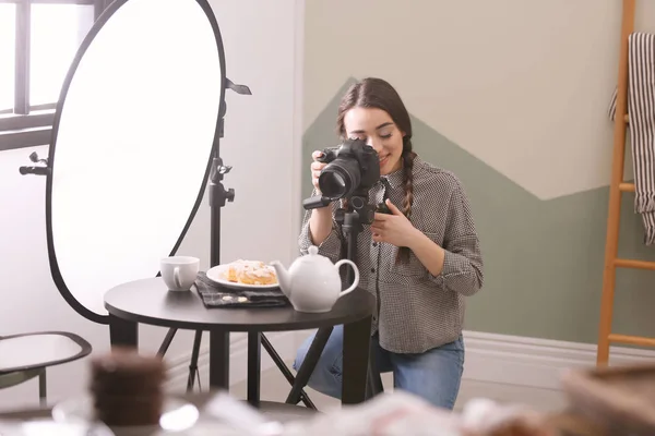 전문 카메라를 가지고 스튜디오에서 식품 사진을 찍고 있는 젊은 여자 — 스톡 사진