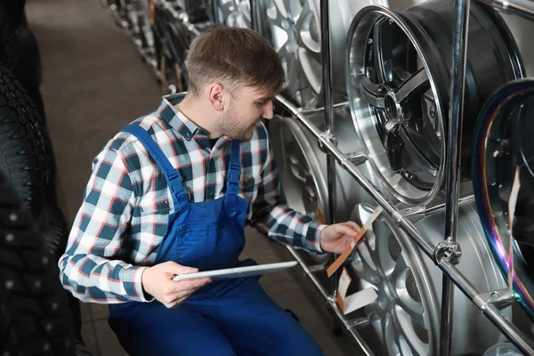 Mladý muž mechanik s tabletový počítač v automobilový servis — Stock fotografie